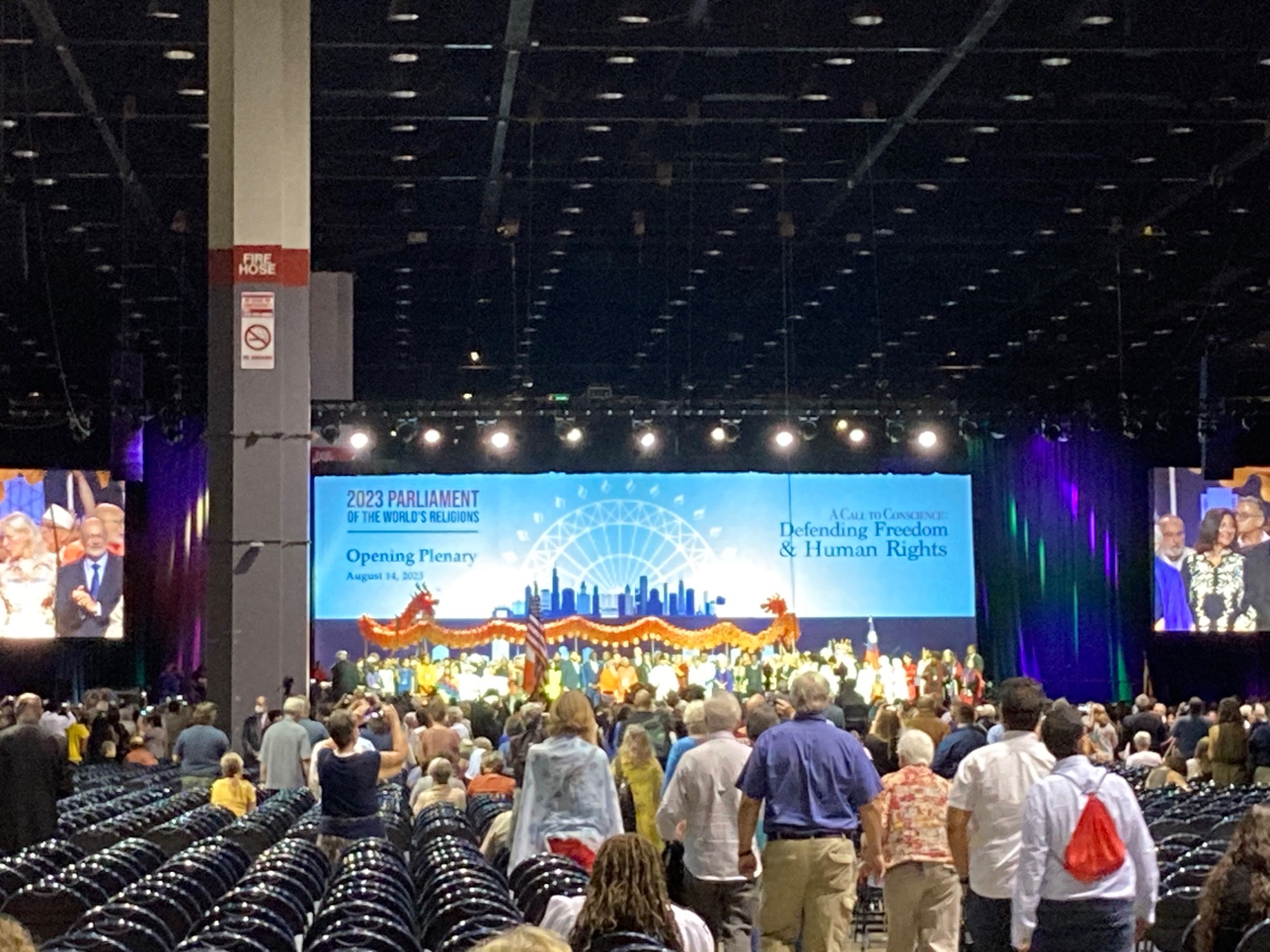 People gathered around a stage with Chinese dragon